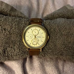 Fossil watch, gold with diamonds and brown leather band.